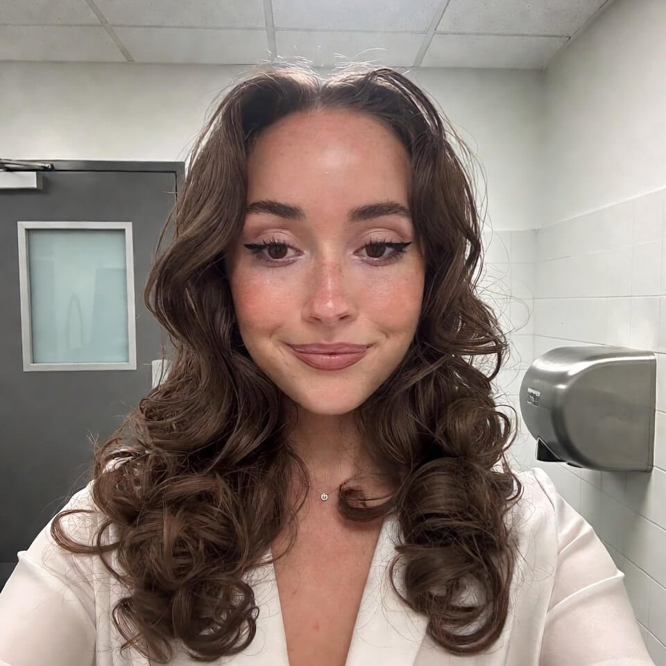Office bathroom mirror selfie with smudged eyeliner and fake smile